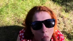 Kinky redhead with big tits gives a blowjob outdoors